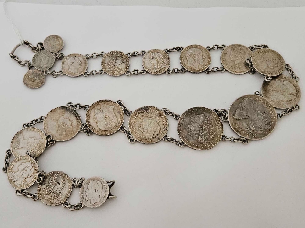 A SILVER COIN BELT 27” LONG - TOTAL OF 19 COINS INCLUDING A 1706 ANNE CROWN, 1818 GEORGE III CROWN,