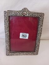 A VICTORIAN PHOTO FRAME WITH SILVER EMBOSSED BORDER,