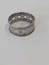 A SILVER NAPKIN RING WITH PIERCED DECORATION,