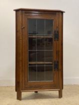 An oak corner cabinet, early 20th century, the lead camed glass door enclosing two shelves, on stile