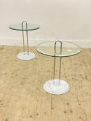 A pair of modern circular glass topped occasional tables raised on twin chrome supports and marble