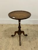 A Georgian style walnut wine table, the scalloped top raised on a turned column and triple splay