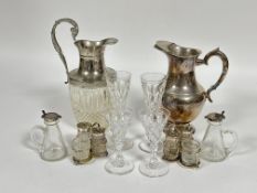 A pair of glass individual custard jugs with Birmingham silver tops, one loose, (H x 10 cm), a