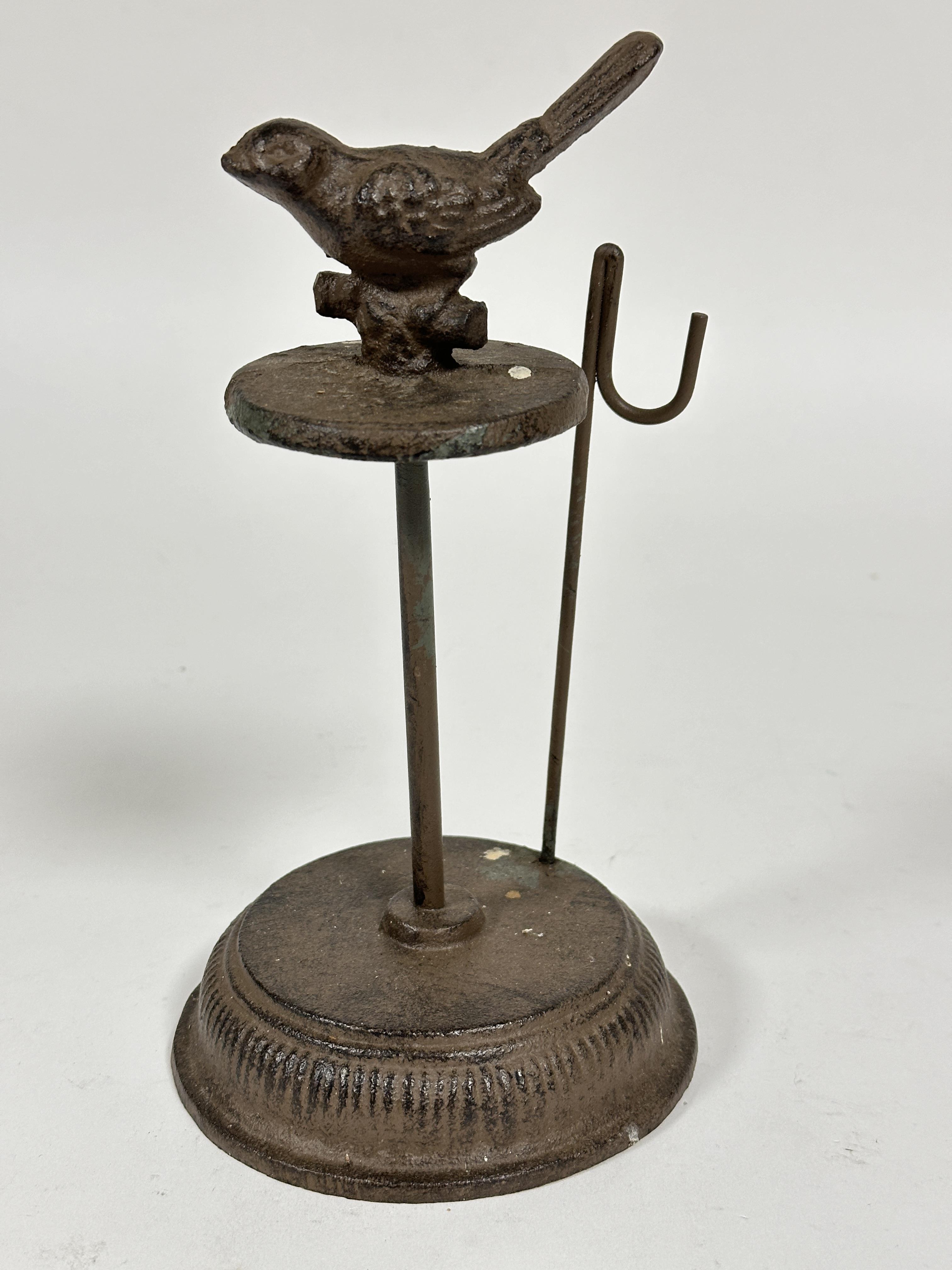A cast iron bird feeder stand with looped rod to side on circular stepped base, (H x 22 cm)