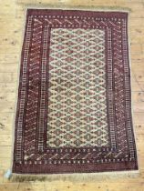 A hand knotted Turkmen rug, the ivory ground of repeating design with lozenges to border 190cm x