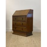 An Art Deco period oak bureau, the fall front opening to a fitted interior, above three drawers,