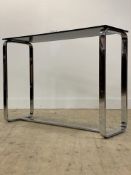 A modern consul table, the rectangular black glass top raised on twin end chrome supports.
