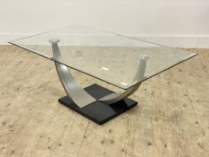 A modern rectangular topped coffee table raised on twin arched polishes steel supports and granite