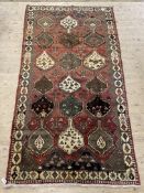 A Persian Shiraz rug, hand knotted, the red abrashed field with geometric design 285cm x 150cm