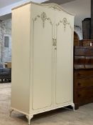 A French style cream and parcel gilt double wardrobe, the two doors with scrolling acanthus design