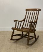 A Victorian stained beech rocking chair, with bobbin turned spindles and supports, on bowed