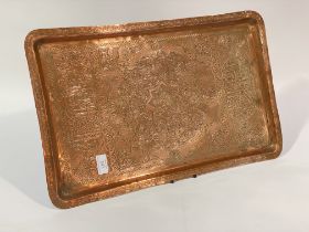 An early 20th century Syrian copper tray, the well decorated with stylised fish, floral motifs and