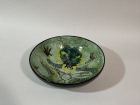 A pottery fruit bowl with Chinese style green five claw dragon chasing the peal of wisdom, unsigned.