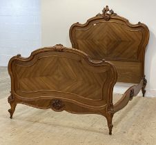 A Louis XV style French walnut double bed frame, late 19th century, the headboard of scrolling