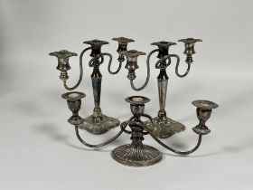 A pair of Epns three branch candelabra on shaped square bases, (H x 25 cm) and a single triple