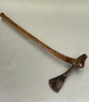 A Luba style axe with patinated metal blade with tolled decoration to cylindrical section inset into