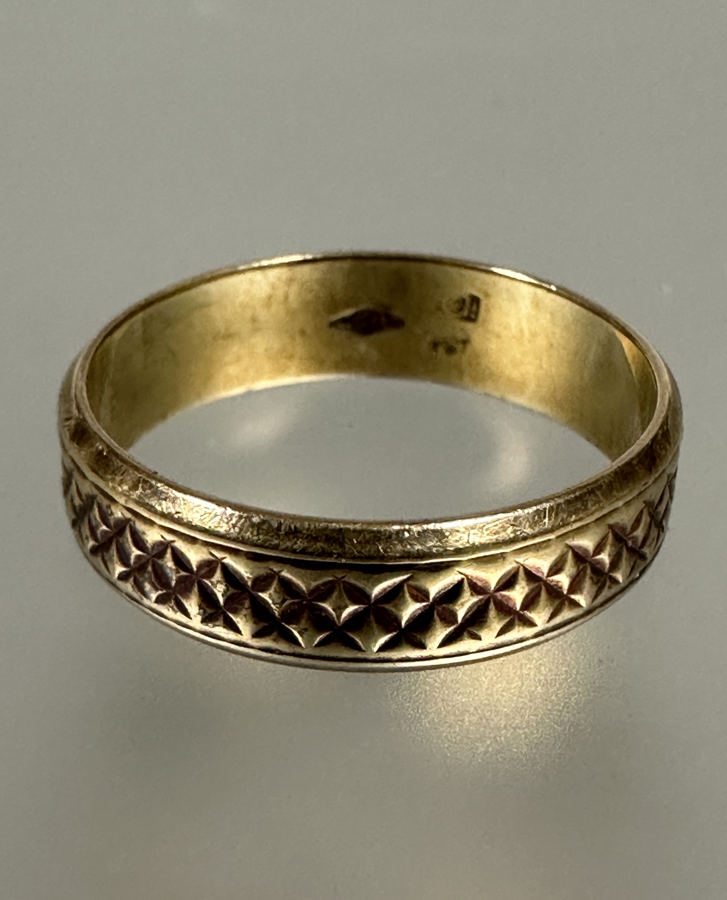 A 9ct gold wedding band with engine turned hatched decoration, R /S. 4.9 g