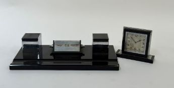 An Art Deco style black glass writing desk set with a built in table calendar, ink well set and