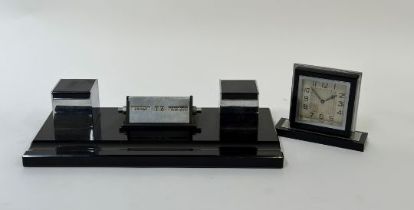 An Art Deco style black glass writing desk set with a built in table calendar, ink well set and