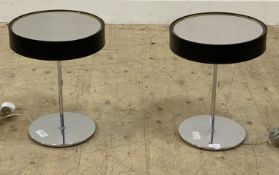 A pair of contemporary chrome table lamps with black cylindrical shades, pull cords, and circular