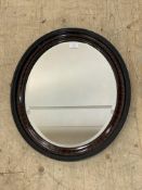 An early 20th century oval wall hanging mirror on a carved and moulded frame 60cm x 40cm.