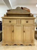 A Victorian style Scotch pine dresser, the shaped back with open shelf above two drawers and two