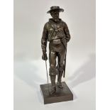 A cast metal standing figure a Cambridge sailor with sword and bronzed finish raised on square base,