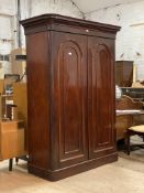 A Victorian mahogany double wardrobe, the projecting cornice over two arch panelled doors