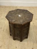 An Anglo-Indian hardwood end table, the octagonal top and folding panelled base carved in low relief