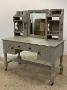 A late Victorian painted dressing table, with bevelled mirror, open shelves, two cupboards and a