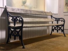 A 19th / early 20th century garden bench, with floral cast iron ends and silvered teak slats.