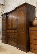 An early Victorian mahogany combination wardrobe with an inverted break front, the projecting
