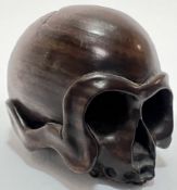 A boxwood momento mori netsuke in the form of a skull (signed verso), the eyes forming a natural him