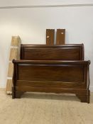 A French style stained hardwood sleigh bed frame with scrolled and panelled head and foot board,
