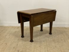 An early 20th century drop leaf kitchen dining table, the rectangular top raised on square tapered