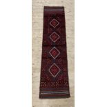 A red ground Meshwani runner rug 230cm x 57cm