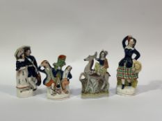 A group of four 19thc Staffordshire figurines, one of a Couple under an umbrella (damage and