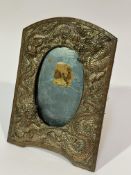 A Chinese 1920's copper silvered arched photograph frame with chased twin dragons chasing the