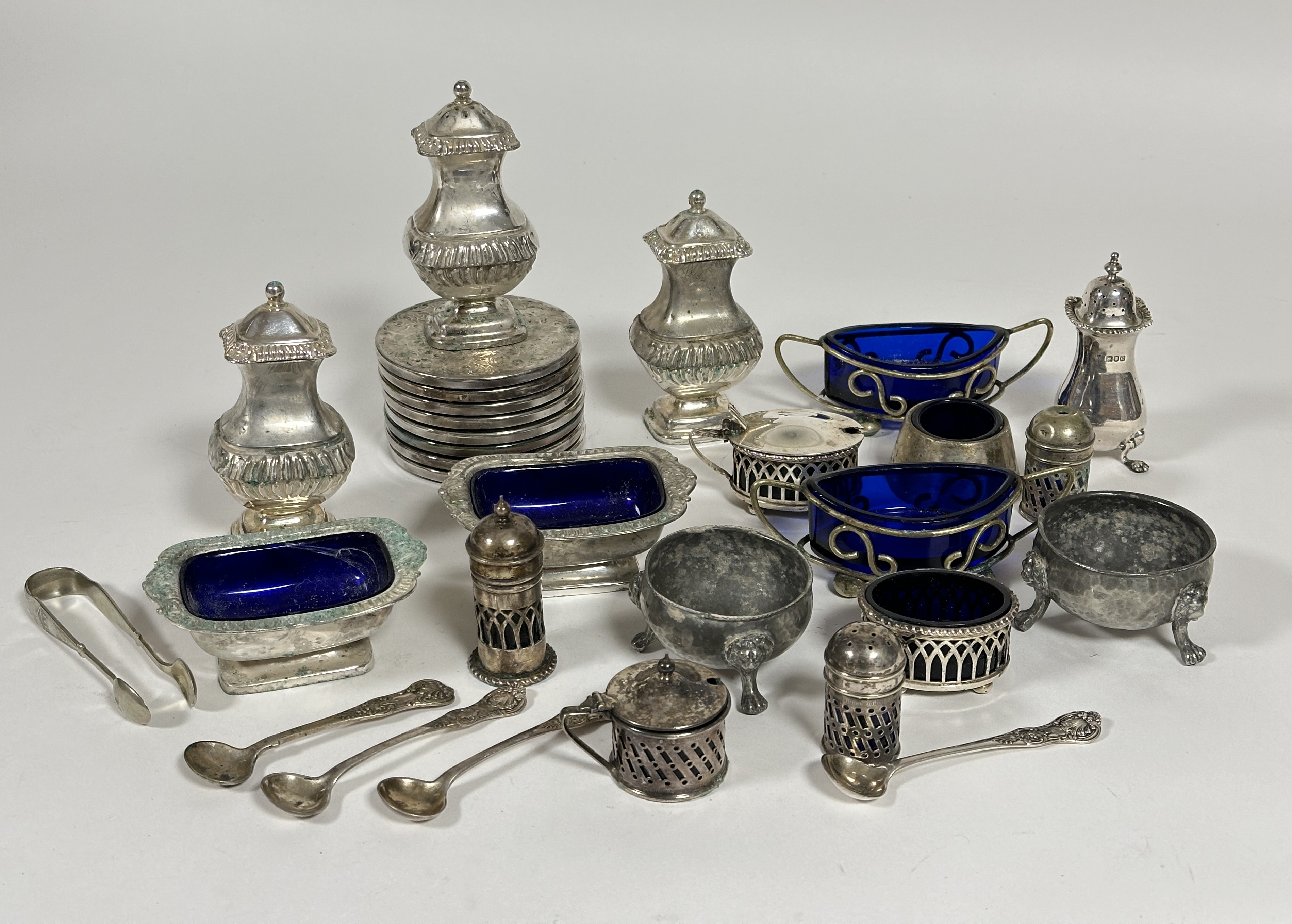 A collection of condiments including a London silver pepperette on paw feet, three Epns