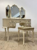 A French style cream and parcel gilt dressing table of kidney form, with triple swing mirror above