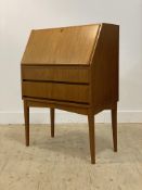 A mid century teak bureau, the fall front opening to a fitted interior, above two graduated drawers,