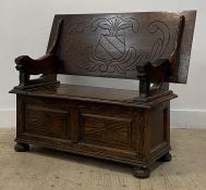 An early 20th century oak monks bench, the carved lift over top on stylised panel supports, above