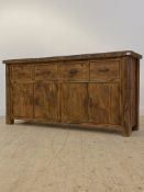 A stained hardwood sideboard, fitted with four drawers over two double cupboards enclosing a