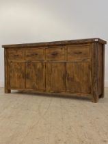 A stained hardwood sideboard, fitted with four drawers over two double cupboards enclosing a