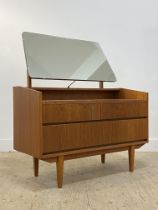 A mid century teak veneered dressing chest, with swing mirror above two short and one long drawer,