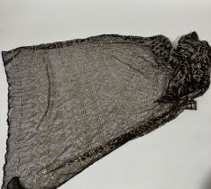 A 1920's Egyptian Assuit shawl, in brown, characteristically decorated with hammered yellow metal