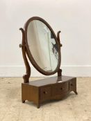 A Georgian style mahogany toilet mirror, the oval plate above a serpentine base fitted with three