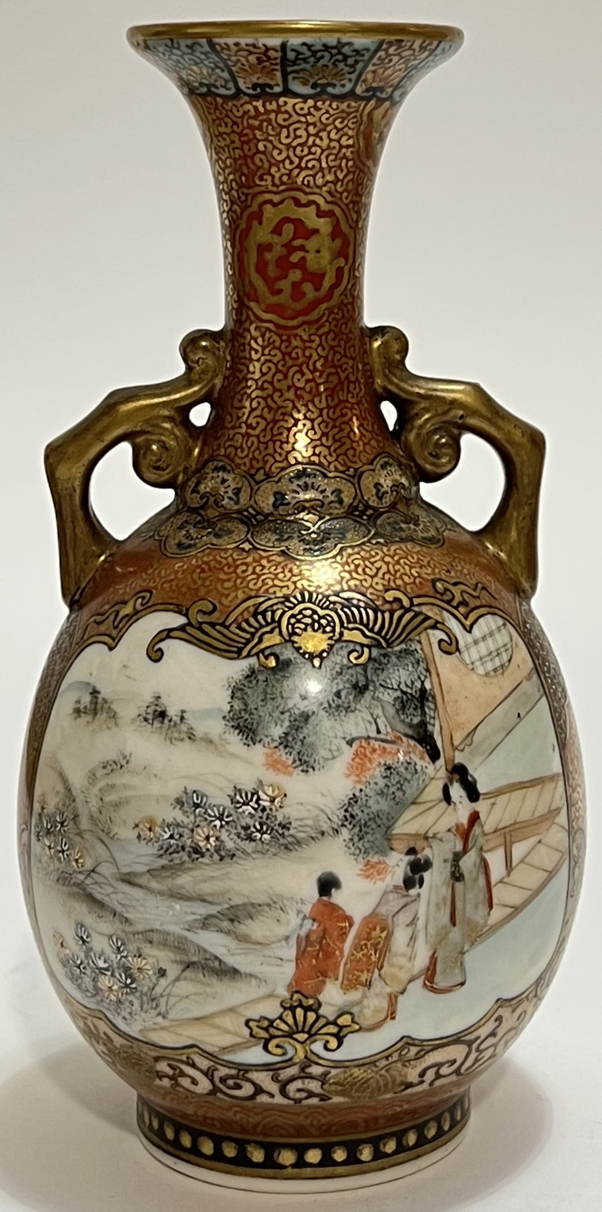 A Japanese Kutani porcelain twin-handled vase decorated in the typical manner with orange and gilt b