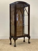An early 20th century mahogany display cabinet, the glazed door enclosing two shelves, raised on