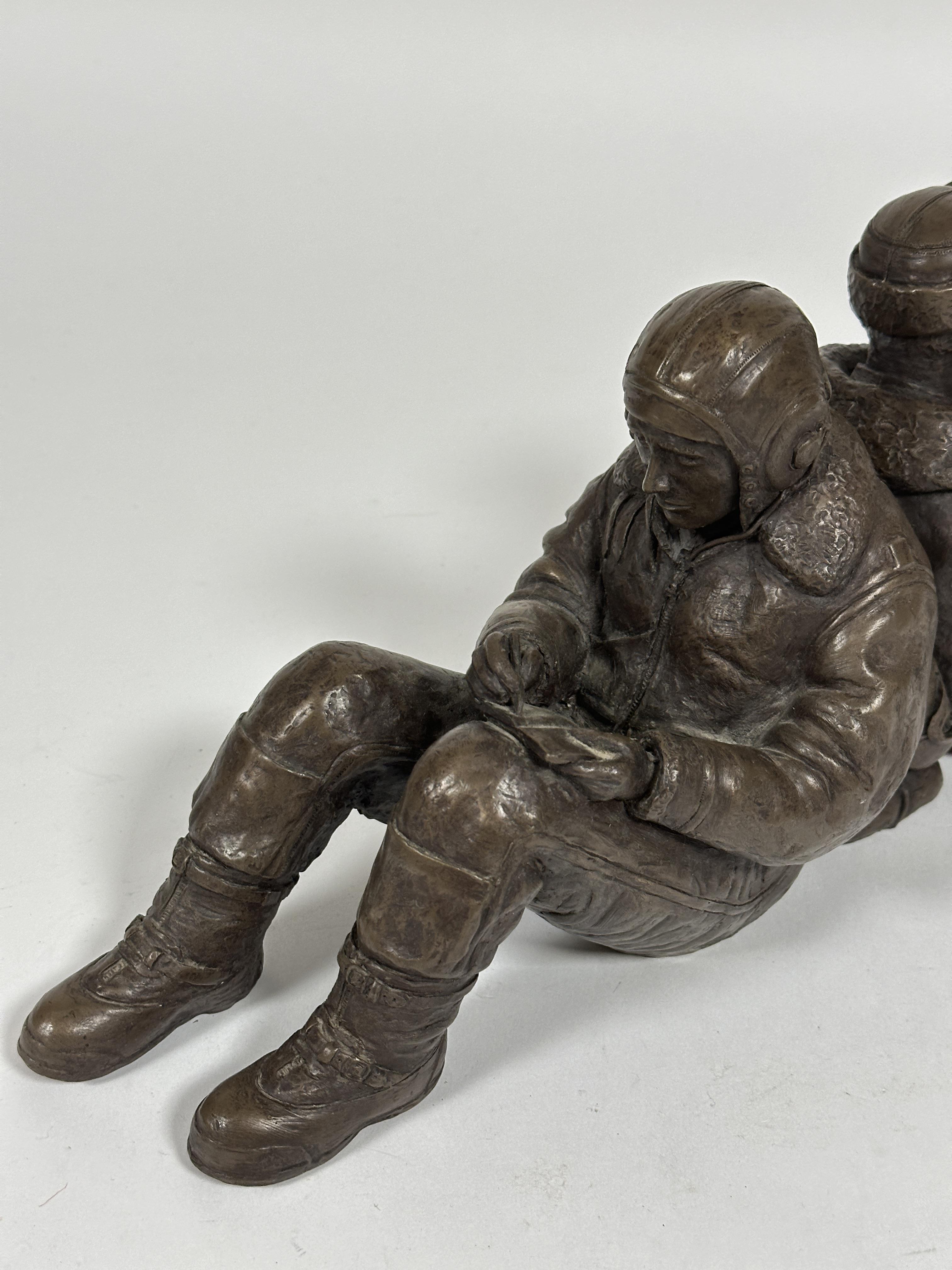 A modern cast resin group of WW II seated back to back airmen one with a dog, unmarked, (H x 17 cm x - Image 3 of 3